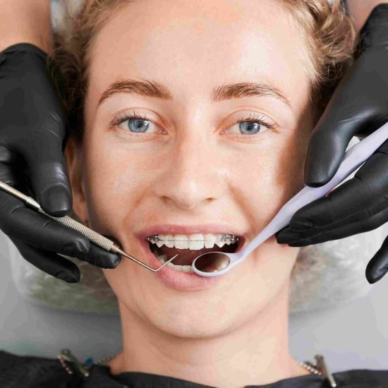 dentist-examining-woman-teeth-with-braces_11zon